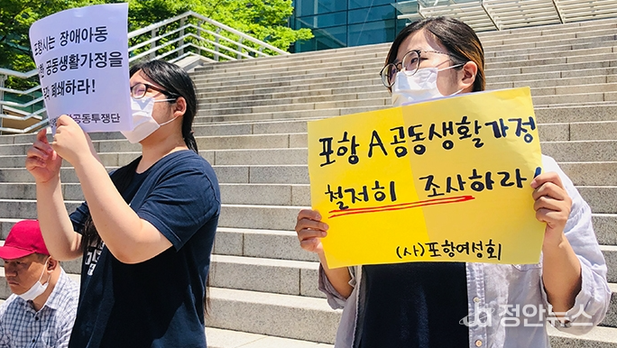 포항여성회 회원이 ‘포항 A 공동생활가정 철저히 조사하라!’라고 적힌 손팻말을 들고 있다. (출처=경북장애인차별철폐연대(준))