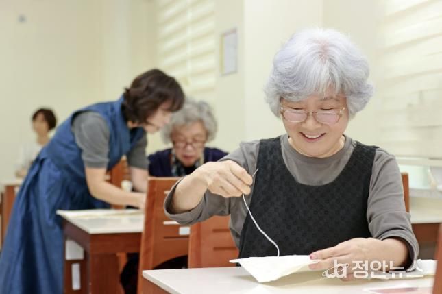 괴산군 웰다잉 프로그램에서 참가자들이 전통 한지로 수의를 만들고 있다