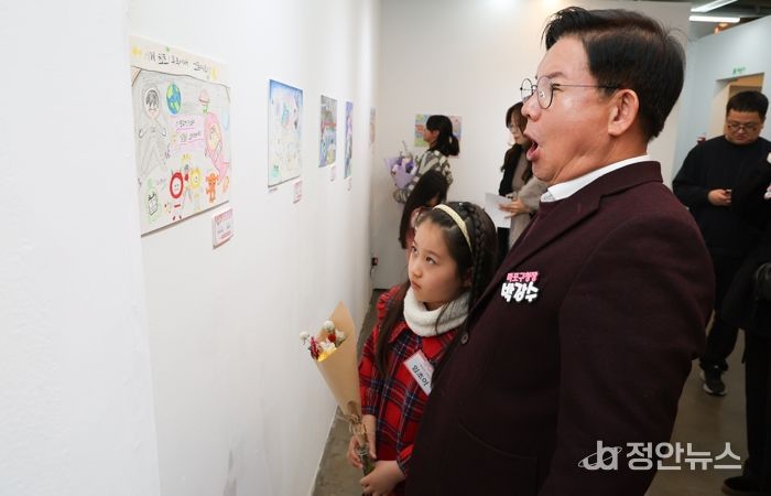 박강수 마포구청장이 수상 어린이와 함께 전시된 그림을 살펴보고 있다.