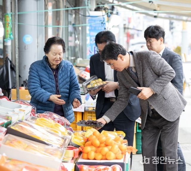 지난달 27일 김돈곤 청양군수가 농어촌 기본소득 지급 첫날 청양 전통시장을 방문해 물품을 구매하며 상인들의 애로사항을 청취하고 있다.